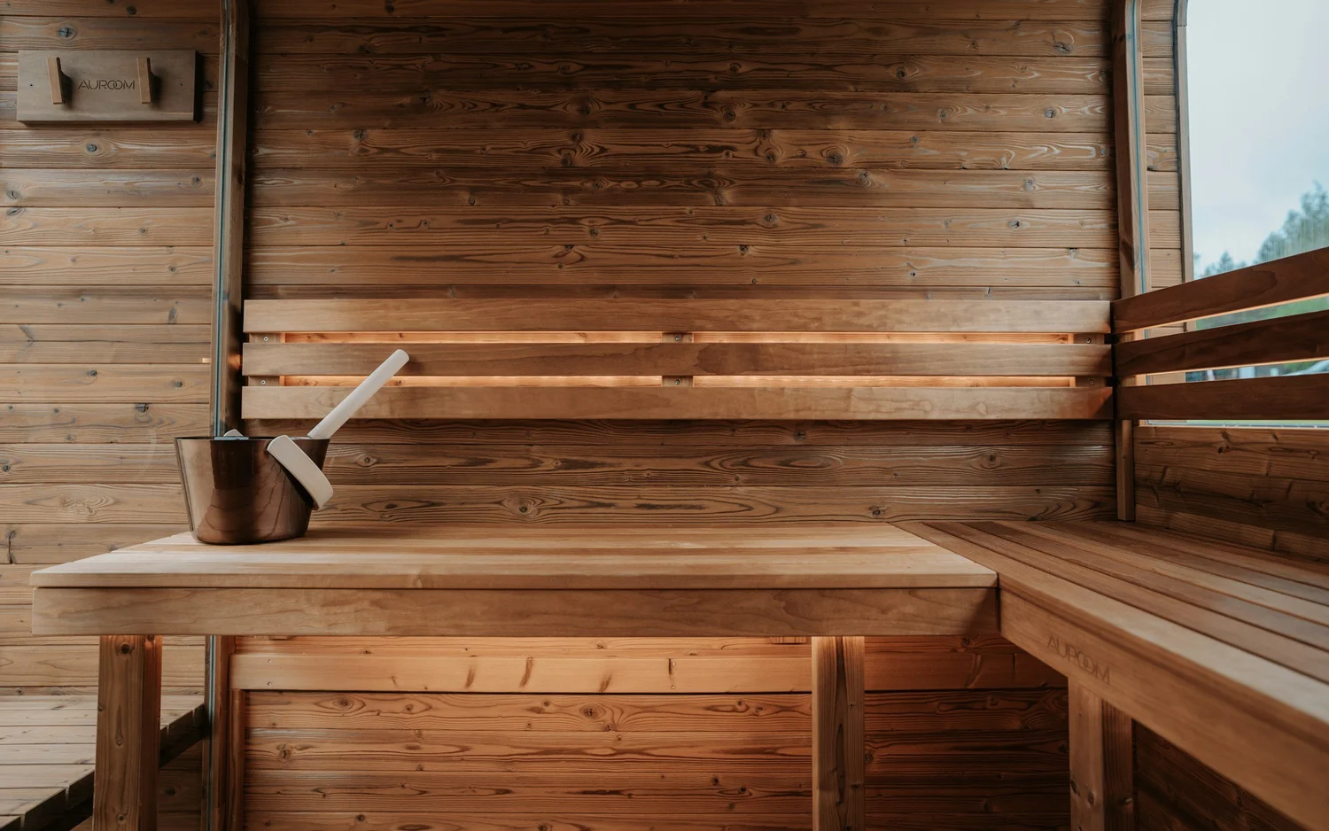 Warm cedar sauna interior with bench seating and lake light